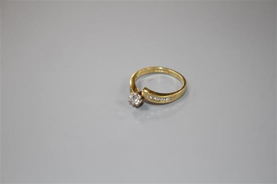 A modern 18ct gold and single stone diamond ring, with diamond set shoulders, size L/M, gross weight 3 grams.